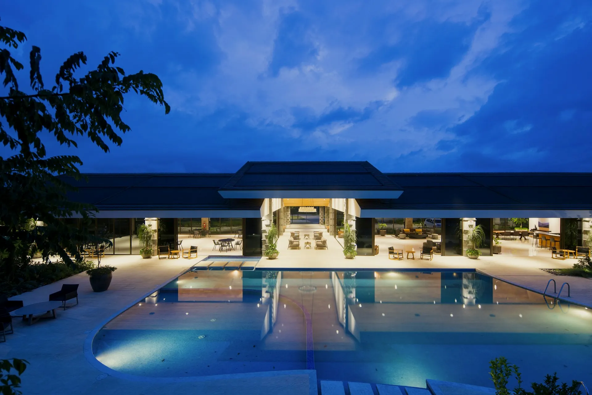 Resort-style infinity pool at blue hour with amber lighting